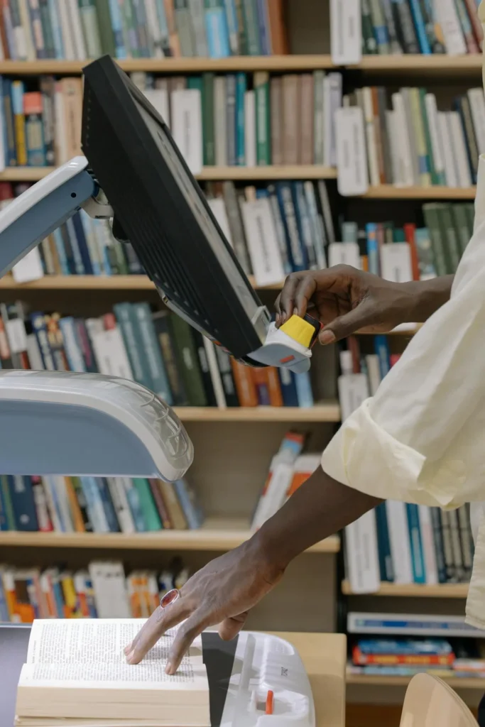 Technician scanning a book using an overhead scanner in a library — professional book scanning service for digitisation and archiving.