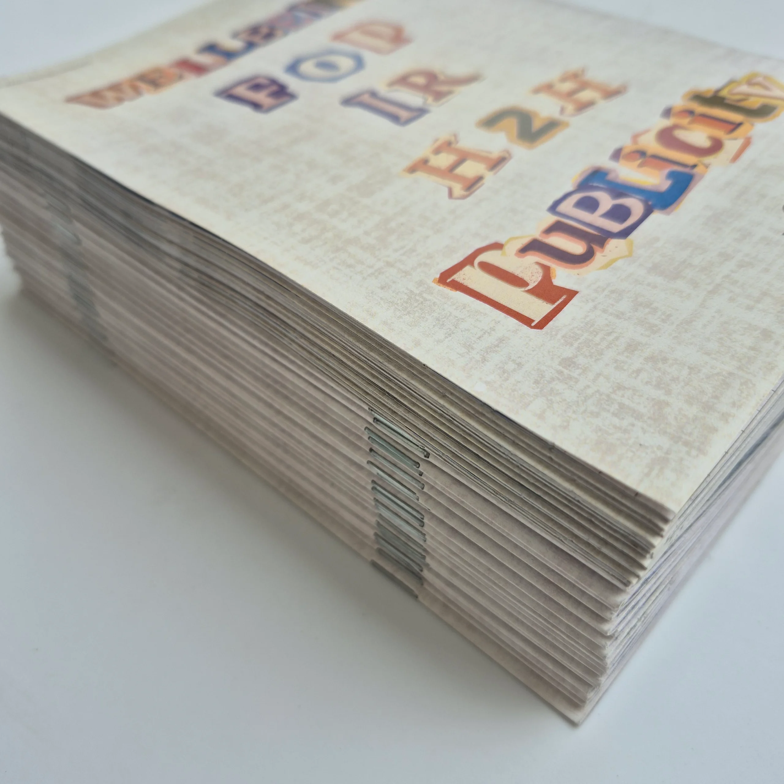 hardcover vs saddle stitch example showing close up of stapled spine on booklet.