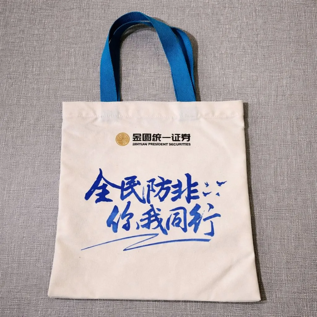 Custom printed canvas tote bag with bold corporate artwork and blue handles